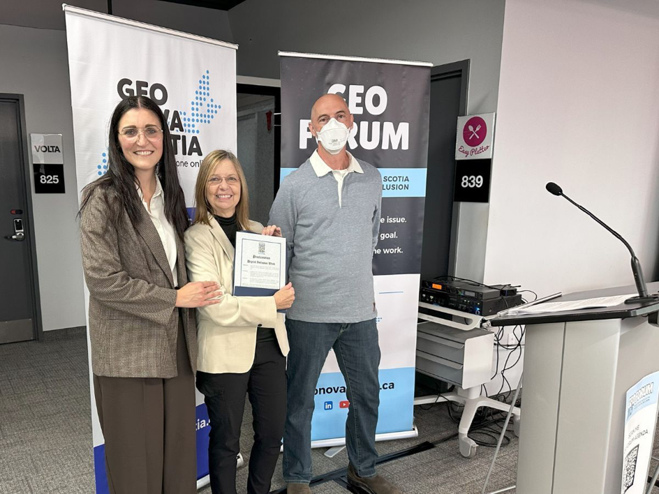This picture shows Minister Jill Balser standing with Bonnie Ste-Croix and Matt Spurway from GEO Nova Scotia. Bonnie is holding the Proclamation of Digital Inclusion Week. 